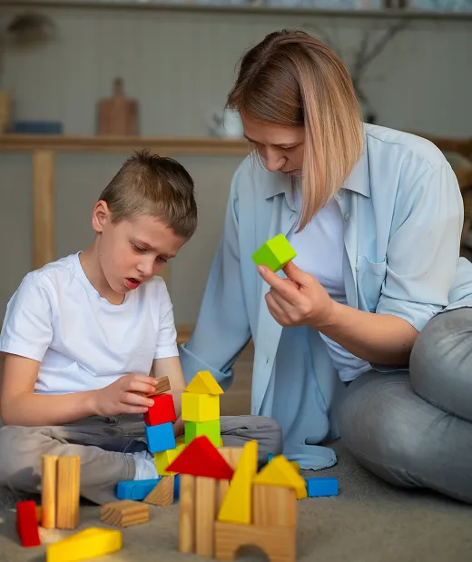 mother playing with her autistic son using toys